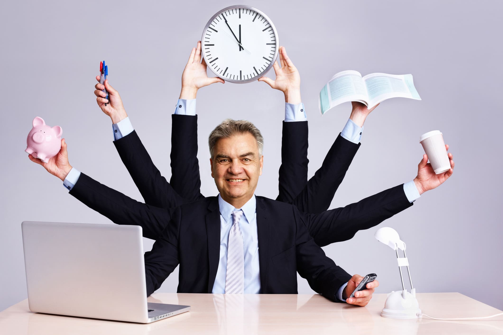 Confident business man multitasking at desk
